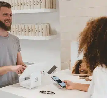 man in grey crew-neck t-shirt smiling to woman on counter