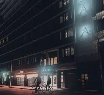 people walking on sidewalk near building during night time