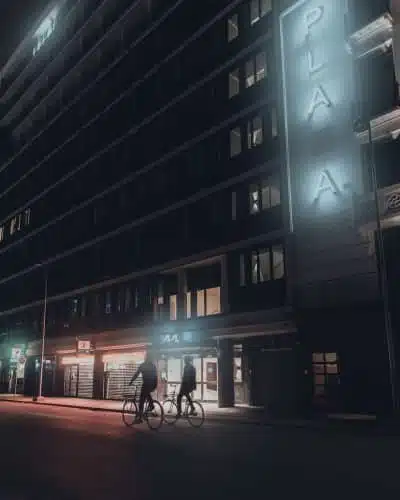 people walking on sidewalk near building during night time